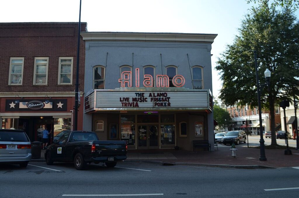 Storefront shot of The Alamo with big neon sign