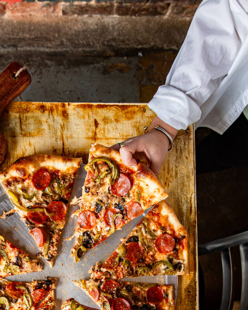 Chef holding large pizza slice