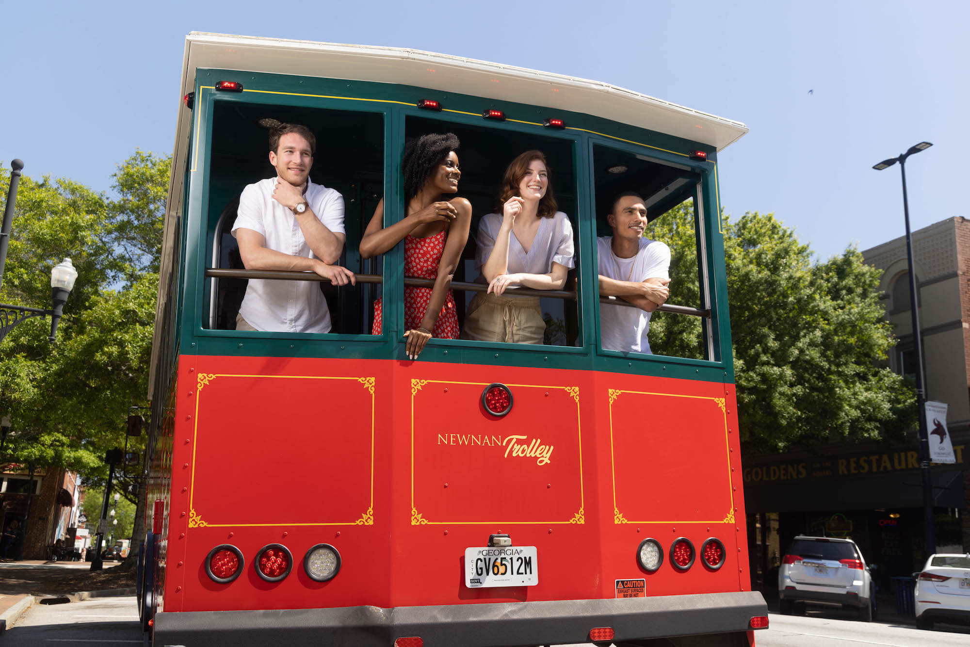 Four people on a trolley looking out the windows