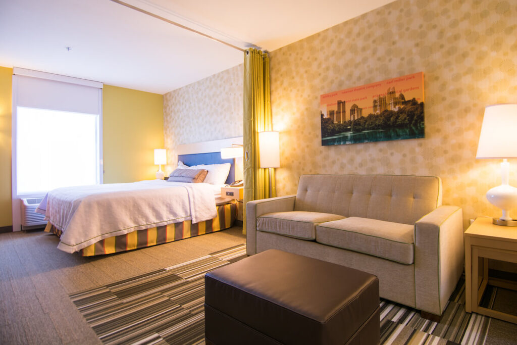 Large suite guest room with bedroom area and living area at Home2Suites by Hilton