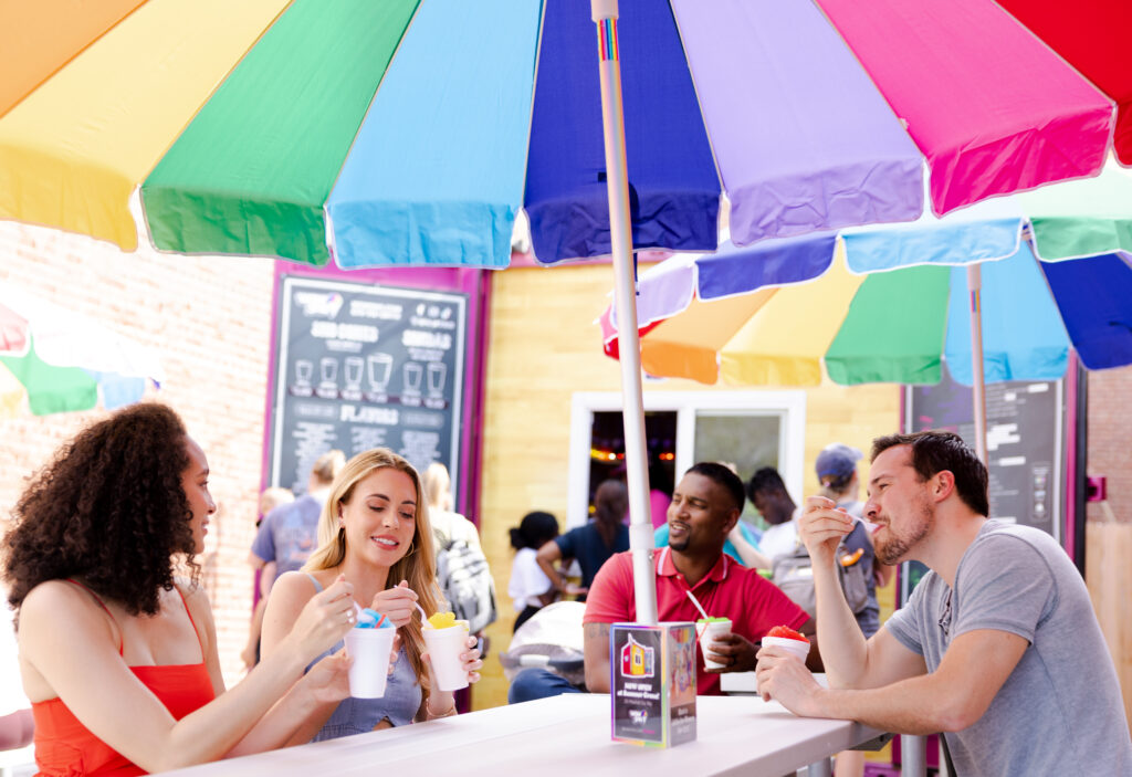 2 guys and 2 girls enjoying different flavors of Italian ice